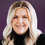 Annie Thurber smiling with wavy blonde hair against a purple background